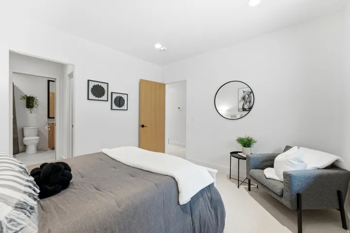 Carpeted bedroom featuring baseboards and ensuite bathroom