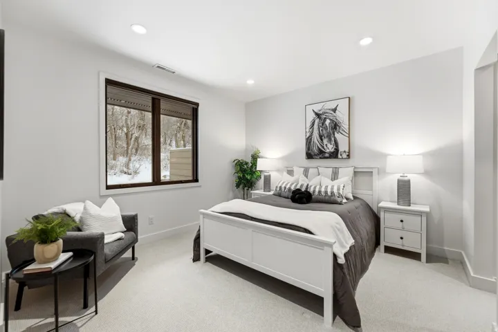 Bedroom with light colored carpet and recessed lighting
