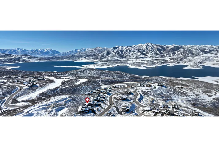 Snowy aerial view featuring a water and mountain view