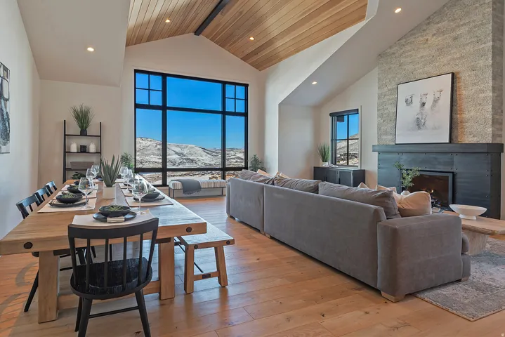 Living room featuring a mountain view, light wood-style flooring, a warm lit fireplace, and recessed lighting