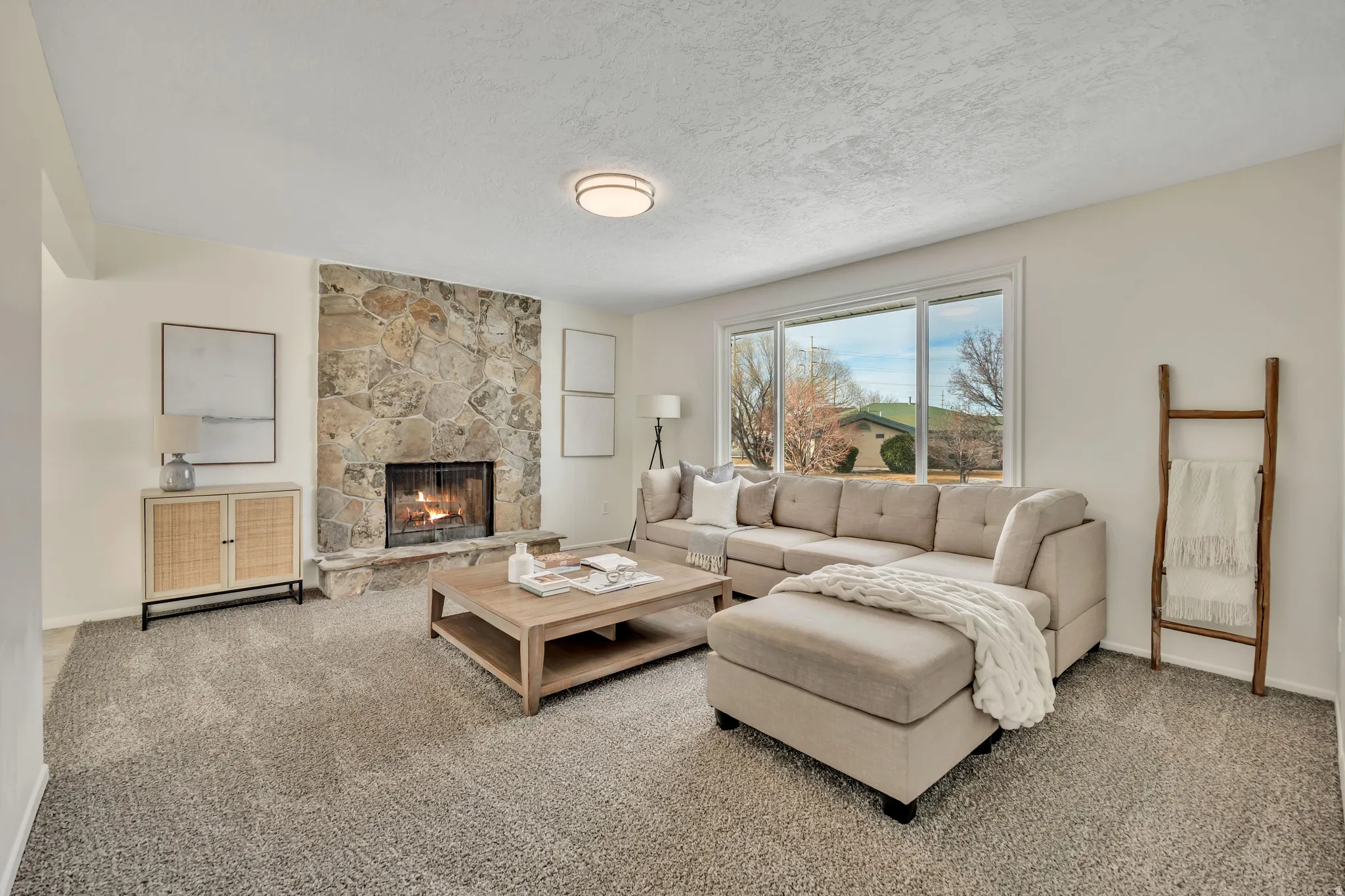 Carpeted living room featuring a fireplace and a textured ceiling