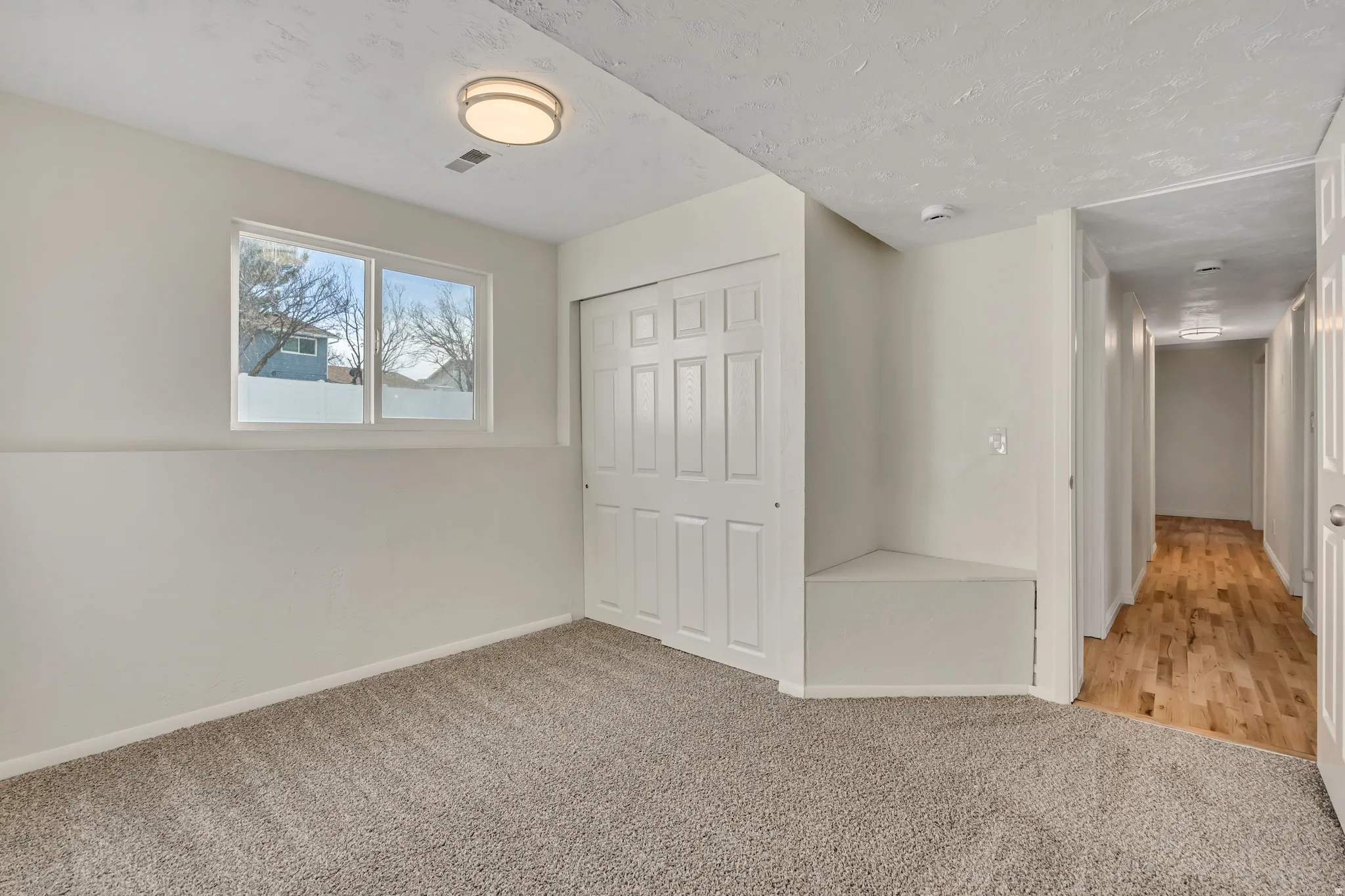 Unfurnished bedroom featuring light carpet, a closet, and a textured ceiling