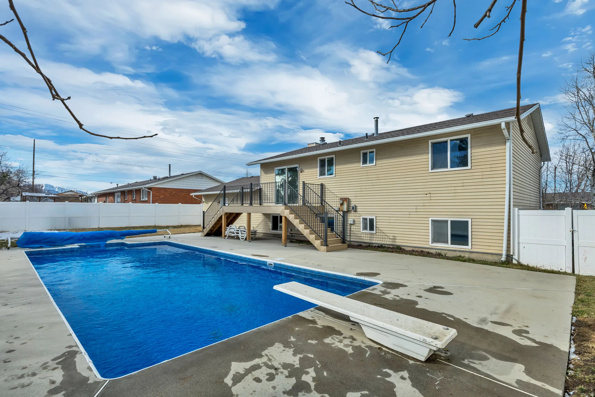 Rear view of property with a fenced backyard, a deck, and a patio