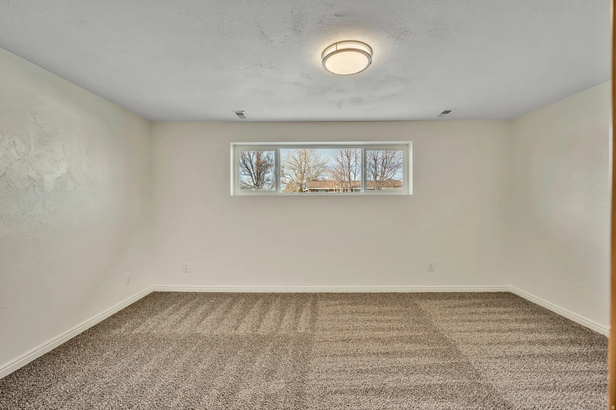 Carpeted empty room featuring baseboards