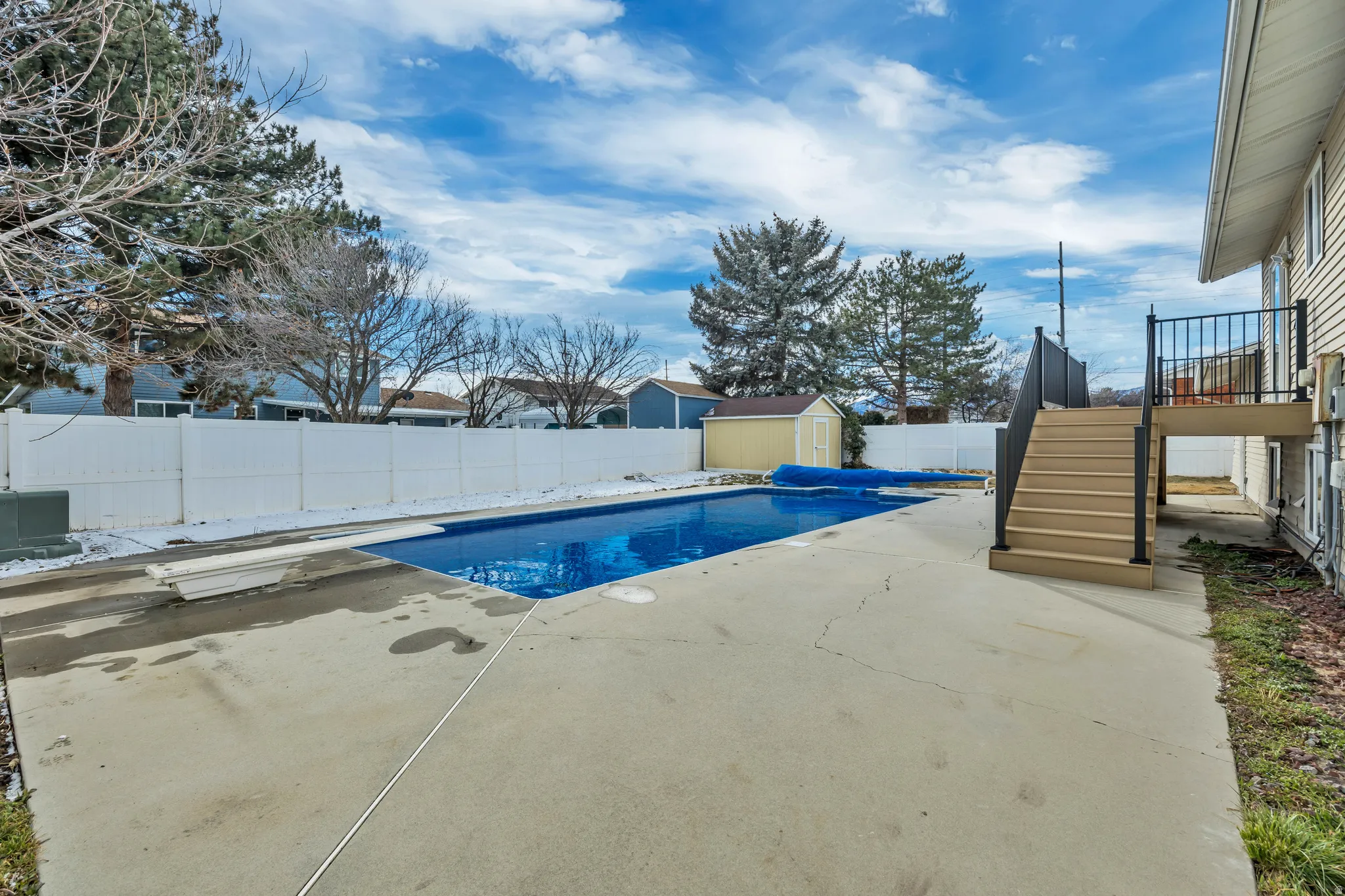 View of swimming pool with patio surround, a storage unit, and a fenced backyard