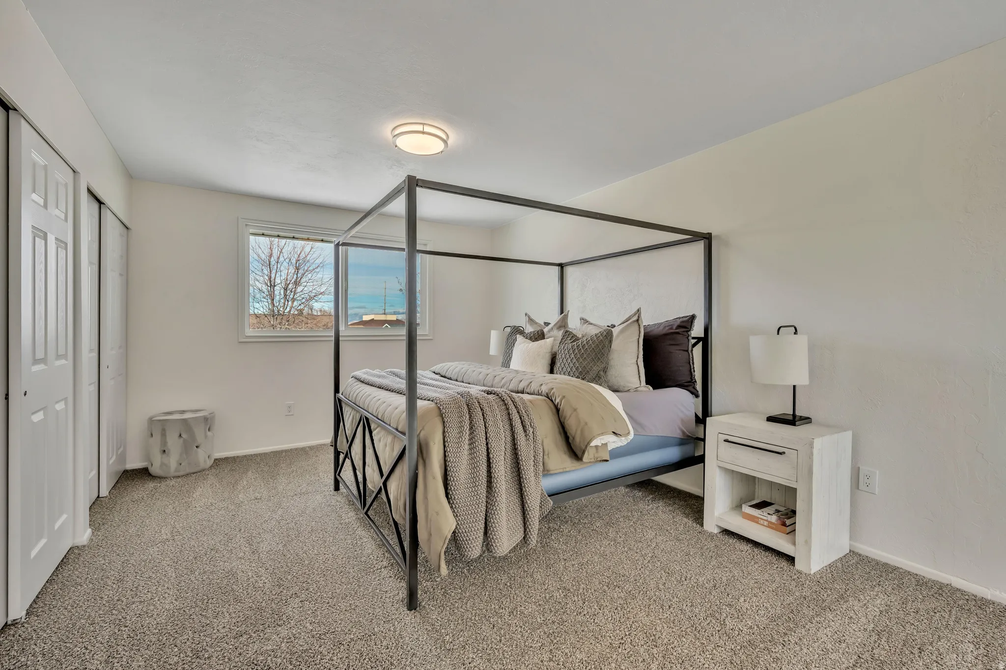 Bedroom featuring light carpet and multiple closets
