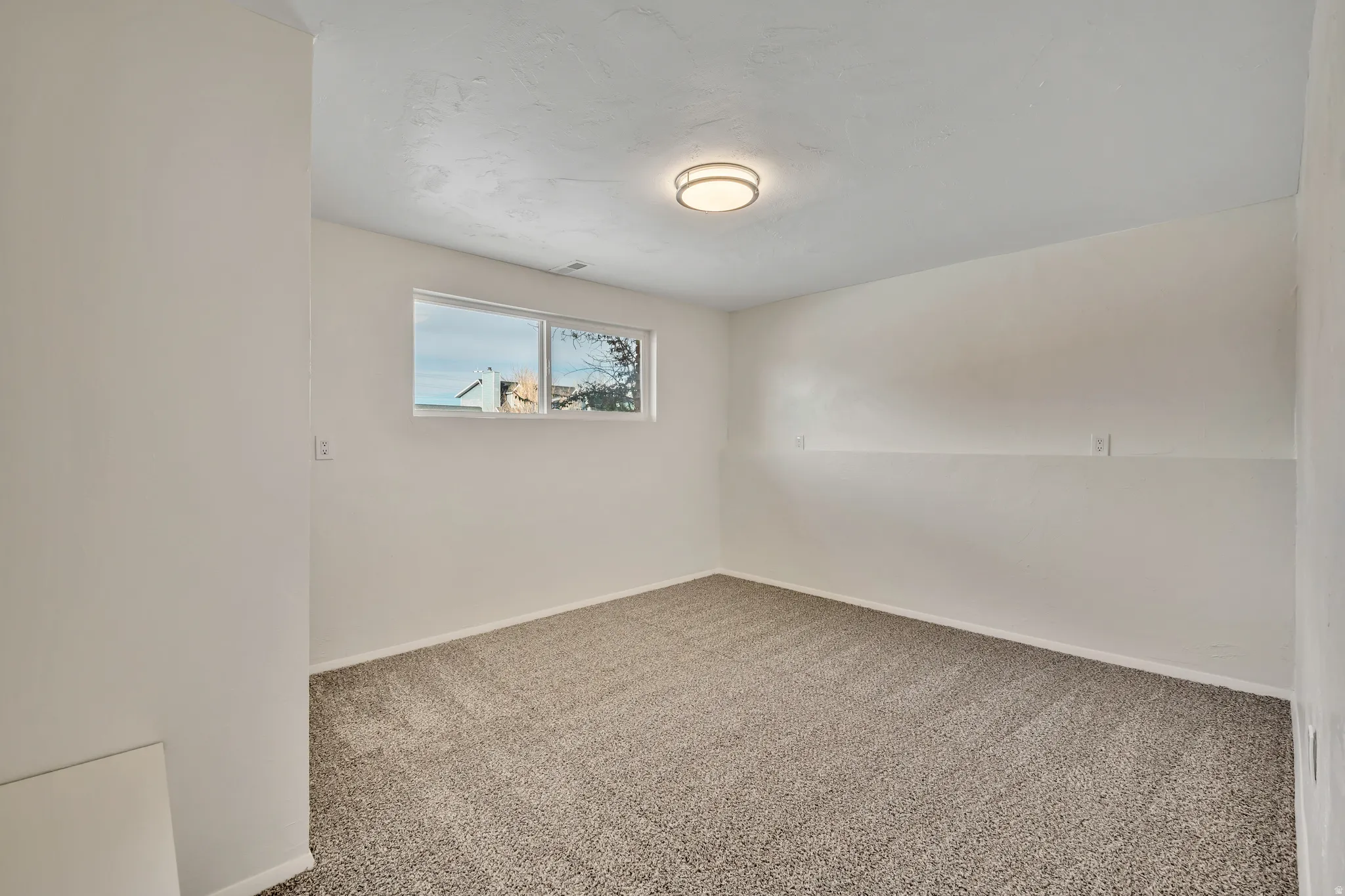 Empty room featuring carpet floors and baseboards