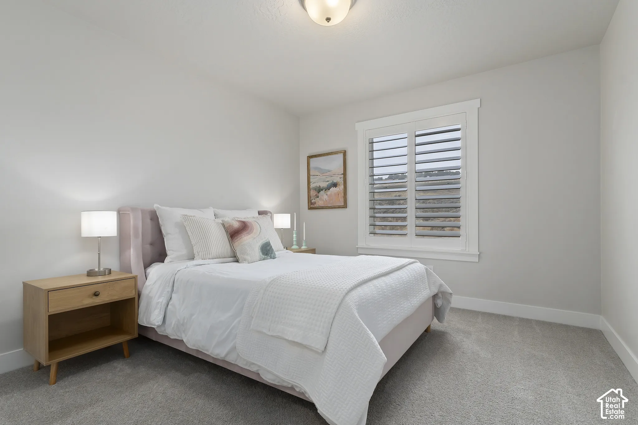Secondary bedroom with plantation shutters, generous closet space, and abundant natural light.