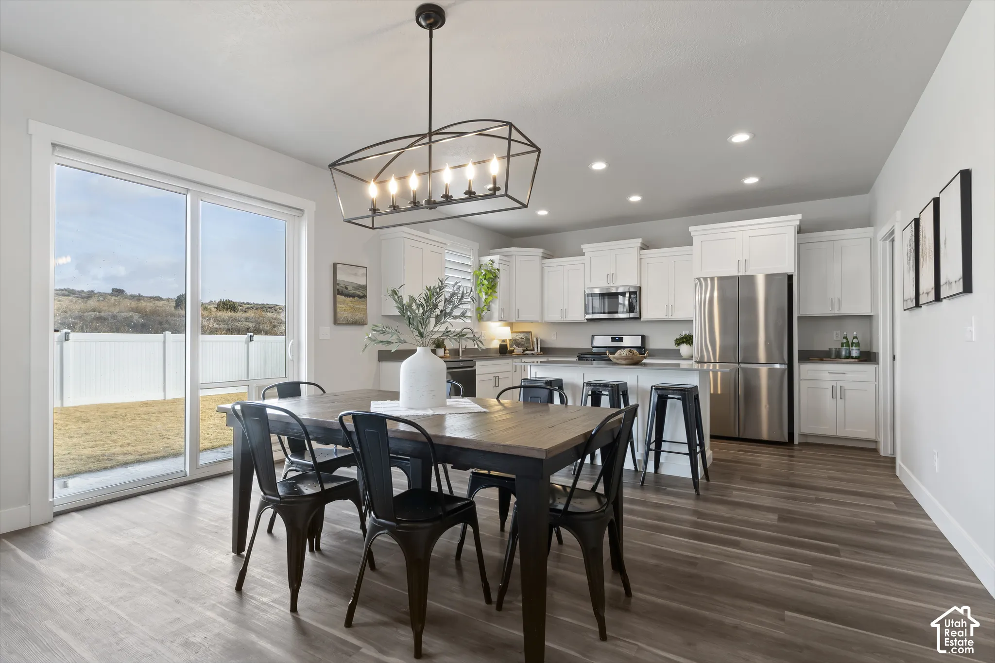 Open dining area seamlessly connected to the kitchen and great room with views of the backyard and mountain backdrop.