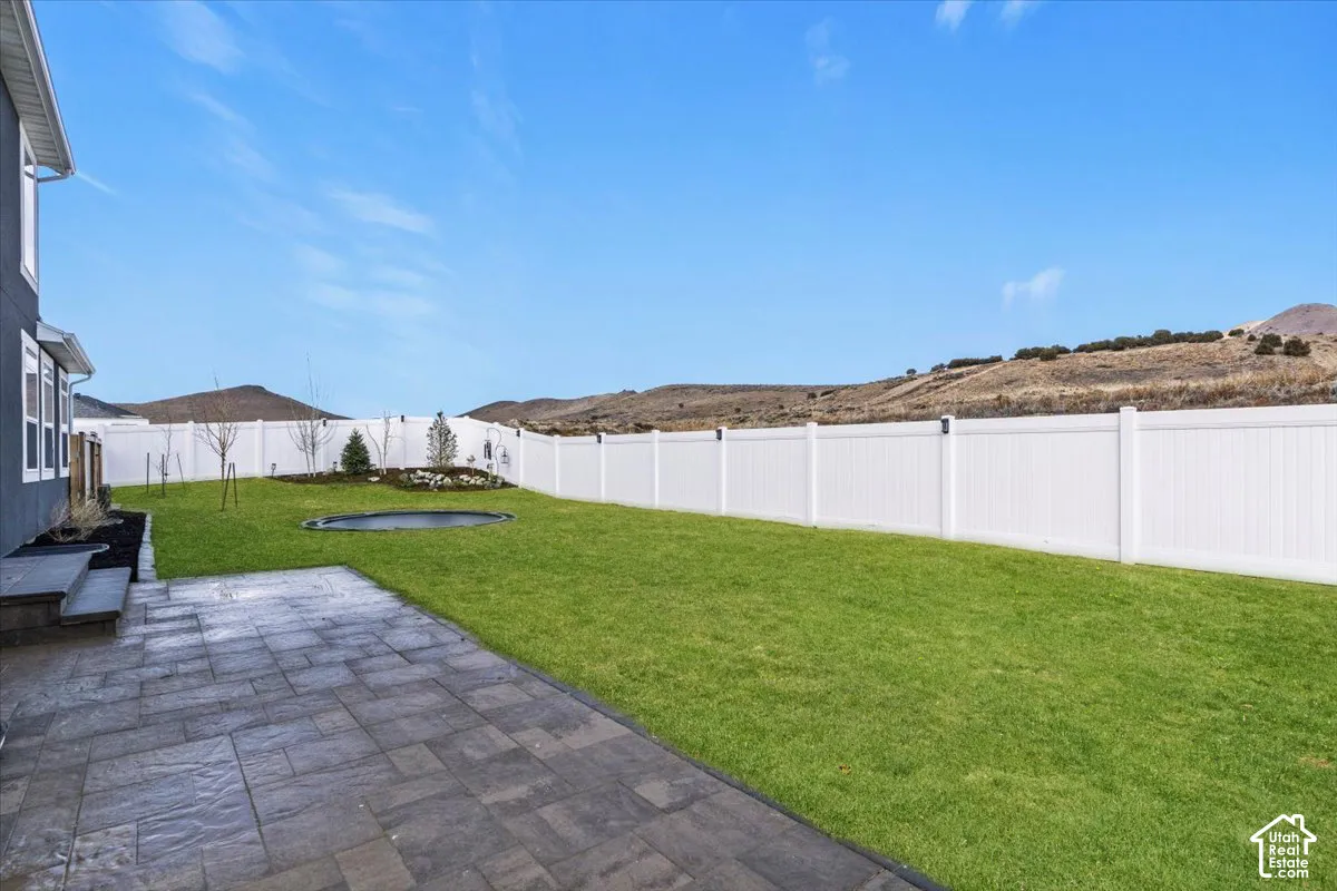 Flat, fully fenced backyard with extended paver patio and room for pets, play, or future landscaping.