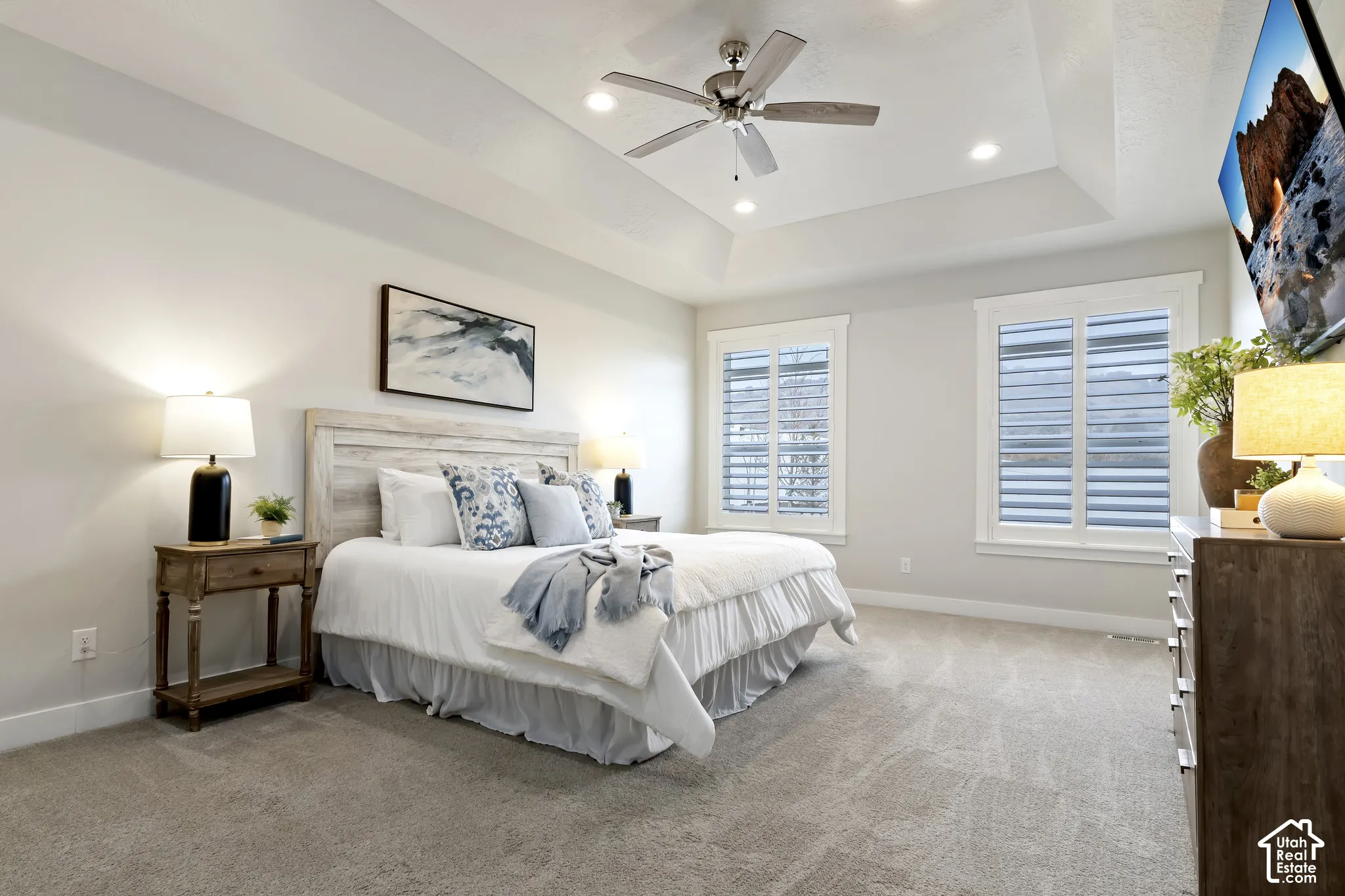 Main-level primary suite featuring a tray ceiling, oversized walk-in closet, and spacious ensuite bathroom.