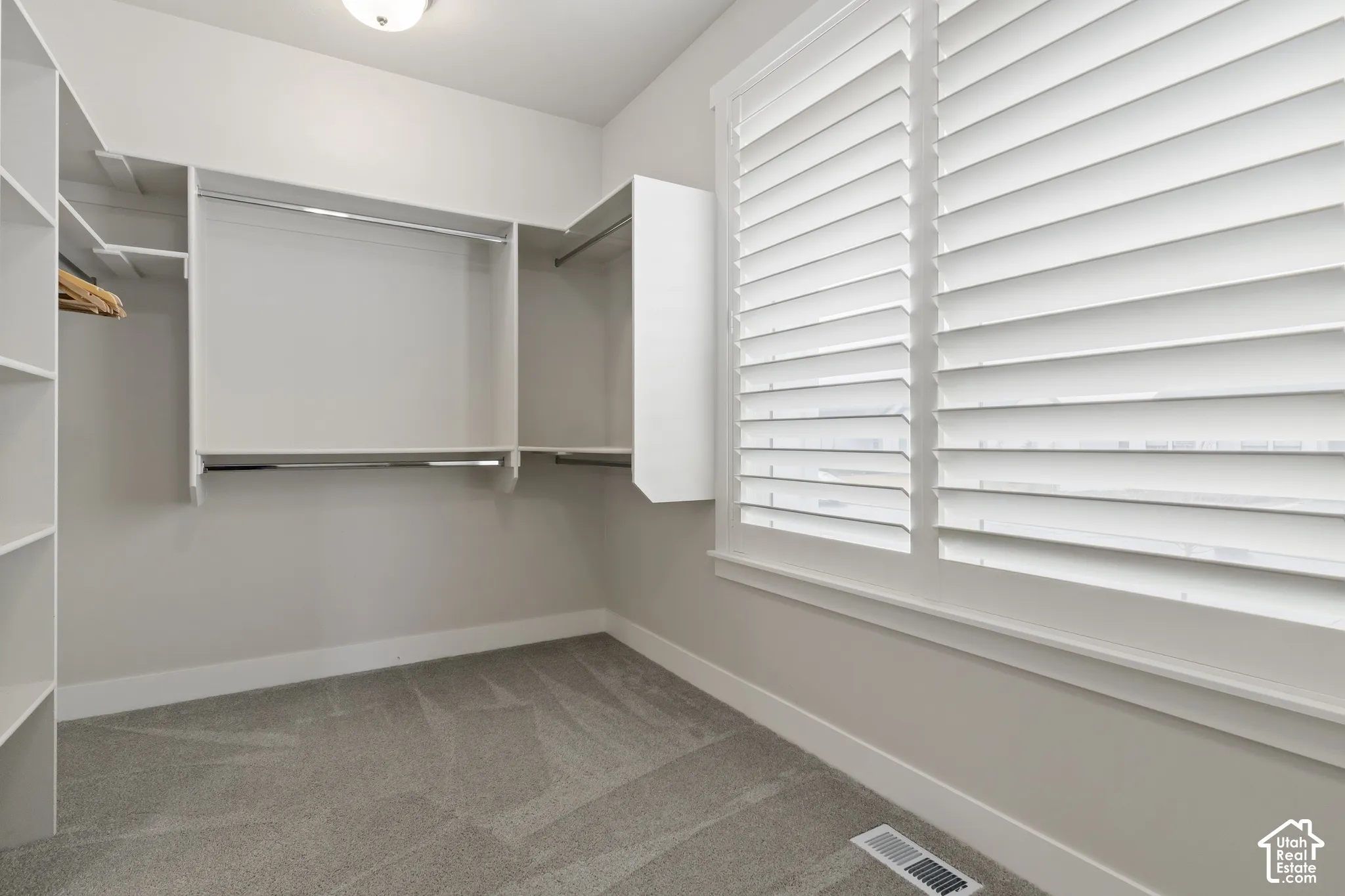 Oversized walk-in closet with built-in shelving and abundant storage.