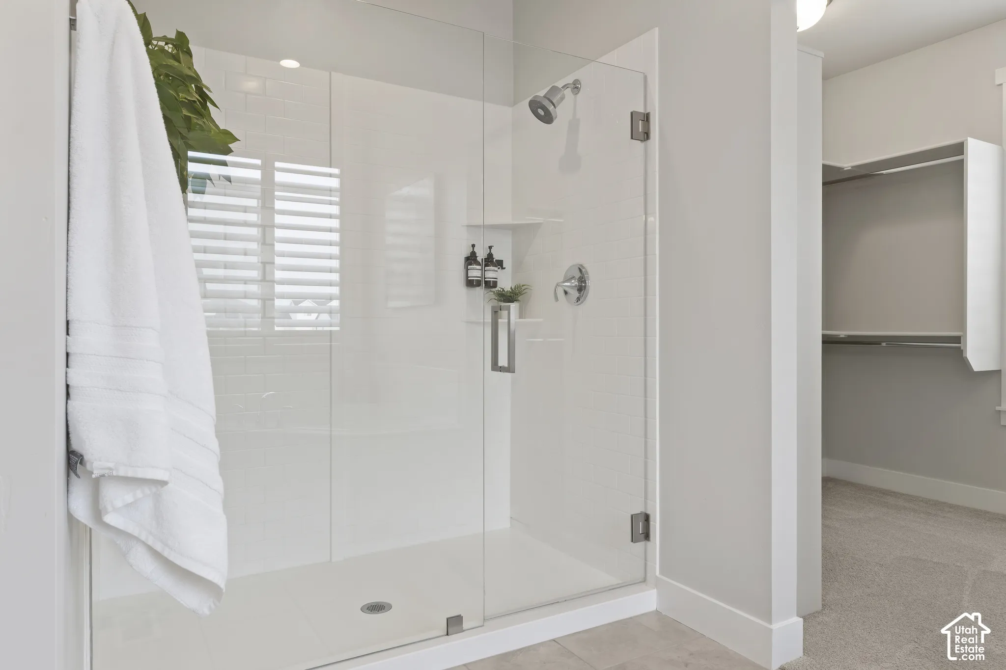 Glass-enclosed shower with adjacent soaking tub and oversized walk-in closet in the primary suite.