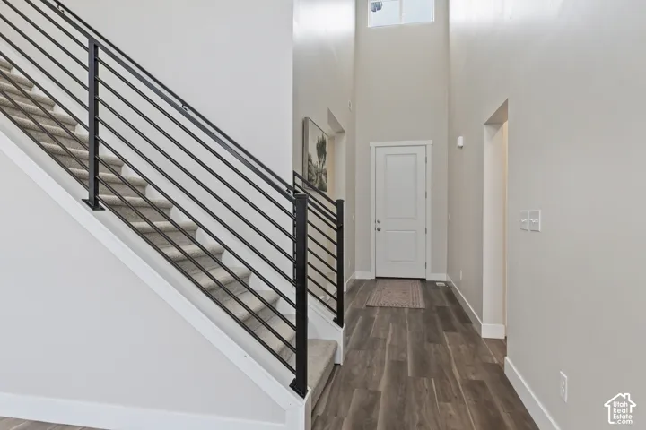 Welcoming entry with soaring ceilings, modern iron staircase railing, and an open view into the main living area.