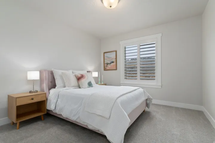 Secondary bedroom with plantation shutters, generous closet space, and abundant natural light.
