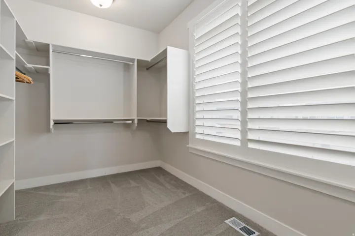 Oversized walk-in closet with built-in shelving and abundant storage.