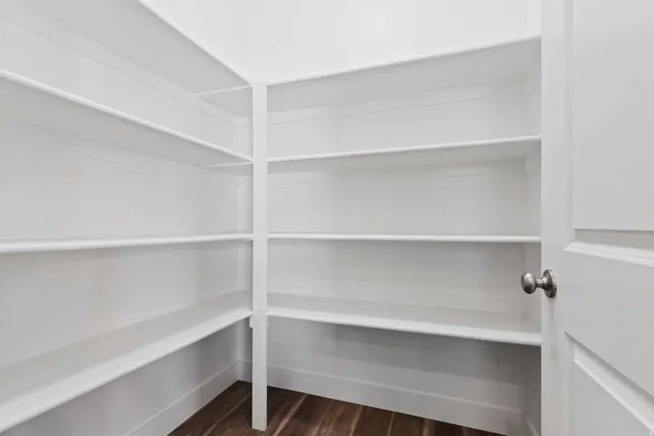 Walk-in pantry with extensive shelving and storage to keep the kitchen organized.