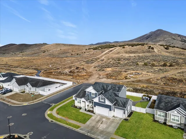 Corner lot with mountain backdrop, mature landscaping, and a fully fenced backyard.