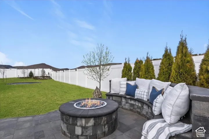 Built-in gas fire pit with curved seating creates a comfortable outdoor gathering space.