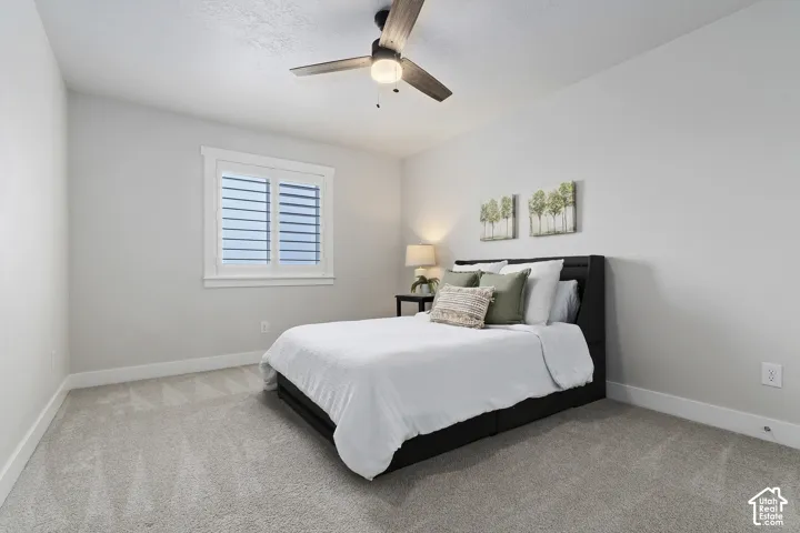 Bright secondary bedroom with ceiling fan, large closet, and plenty of natural light.