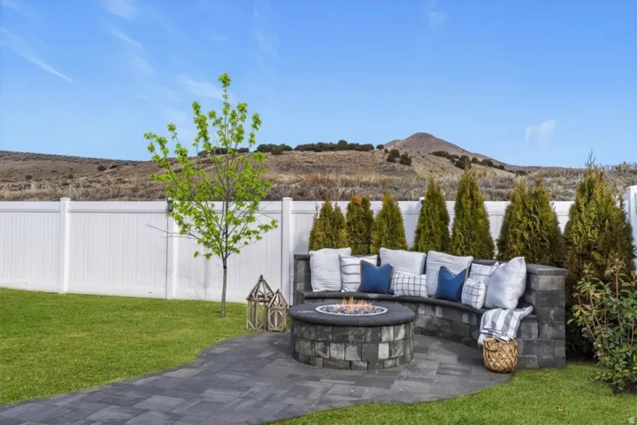 Outdoor living area featuring a built-in gas fire pit, curved seating, and mountain views.