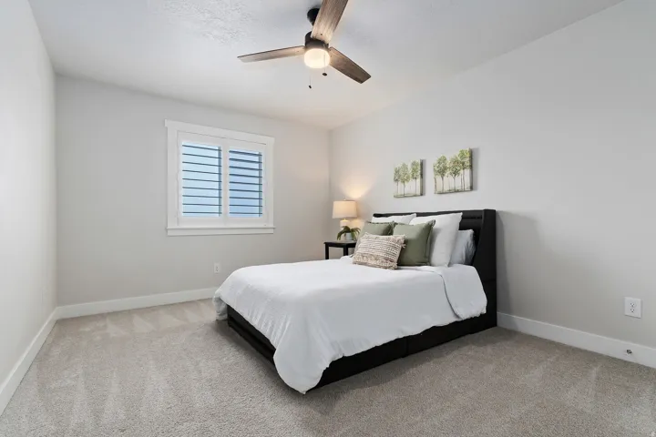 Bright secondary bedroom with ceiling fan, large closet, and plenty of natural light.