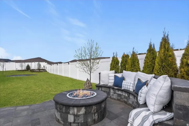 Built-in gas fire pit with curved seating creates a comfortable outdoor gathering space.