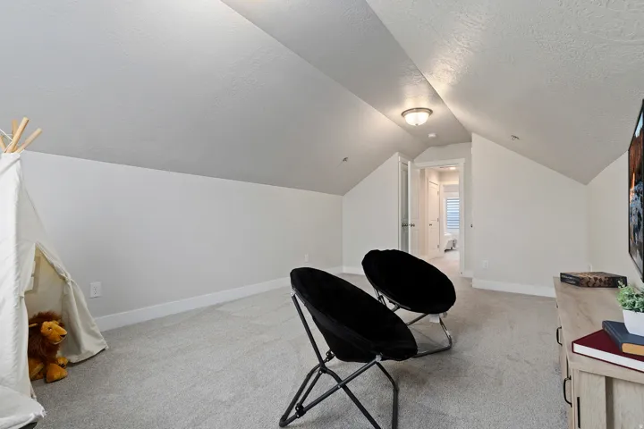 Versatile bonus room with vaulted ceilings offering flexible space for recreation, work, or hobbies.
