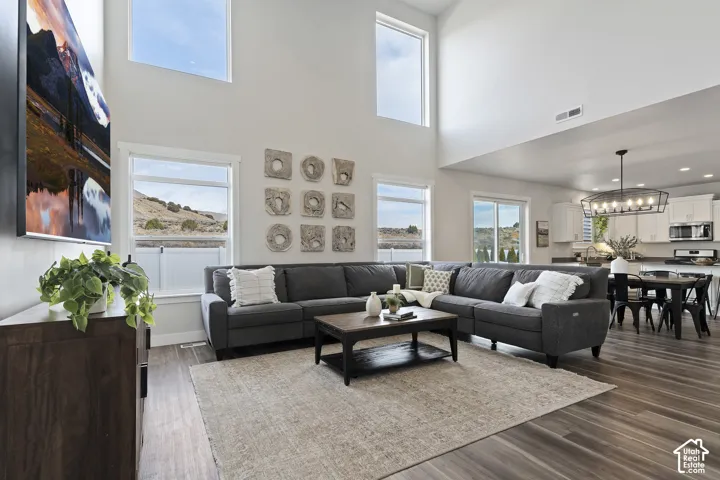 Great room featuring dramatic two-story ceilings, expansive windows, and an open-concept layout connecting the living, dining, and kitchen spaces.