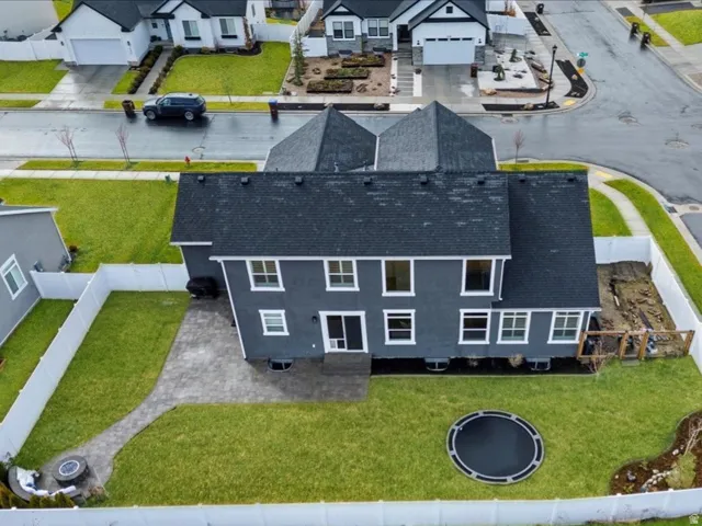 Fully fenced backyard with flat lawn, extended paver patio, and plenty of space for entertaining or play.