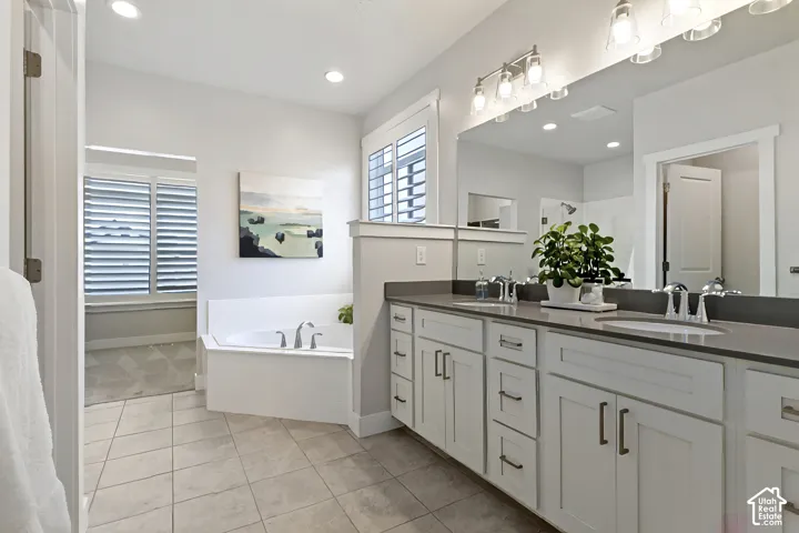 Primary bathroom with dual vanities, soaking tub, separate shower, and spacious layout.