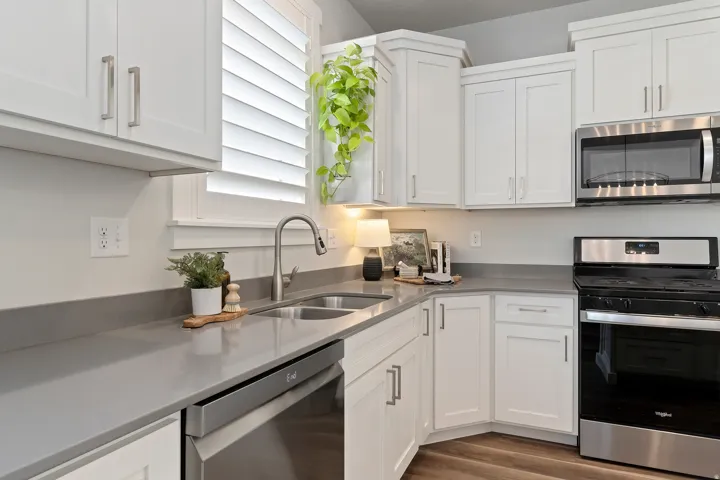 Spacious kitchen with oversized island, white cabinetry, granite countertops, and recessed lighting.