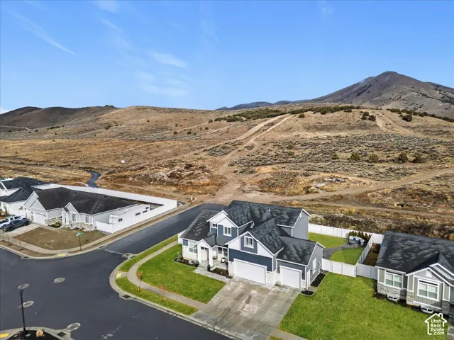 Corner lot with mountain backdrop, mature landscaping, and a fully fenced backyard.