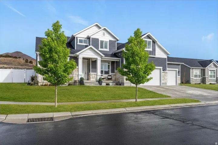 Street view highlighting the corner lot location, mature landscaping, and mountain setting.
