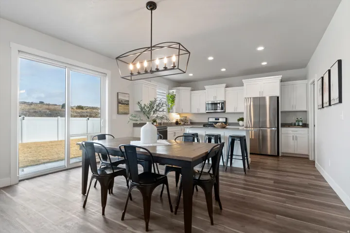 Open dining area seamlessly connected to the kitchen and great room with views of the backyard and mountain backdrop.
