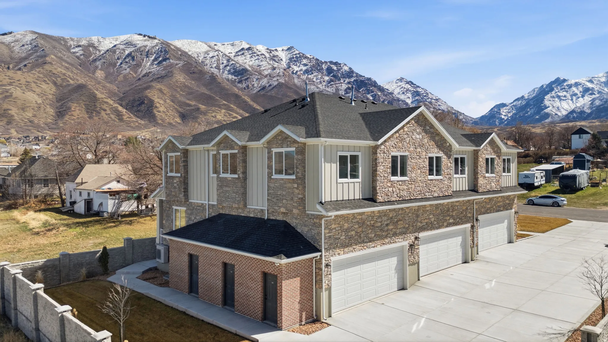 View of front of property featuring a mountain view, a garage, concrete driveway, and a residential view