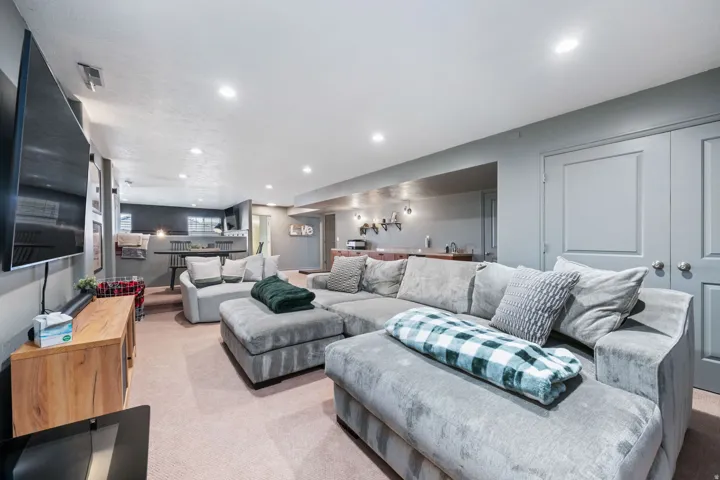 Living area with light colored carpet and recessed lighting