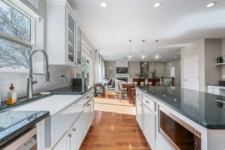 Kitchen featuring dark stone counters, stainless steel appliances, and white cabinets