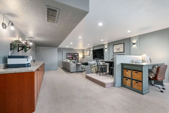 Living area featuring light carpet, recessed lighting, a desk, and a textured ceiling
