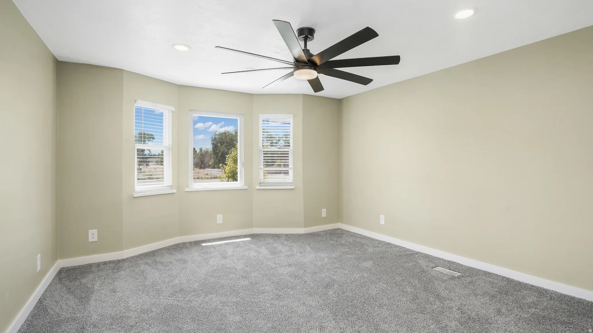 Empty room featuring carpet floors, ceiling fan, and recessed lighting