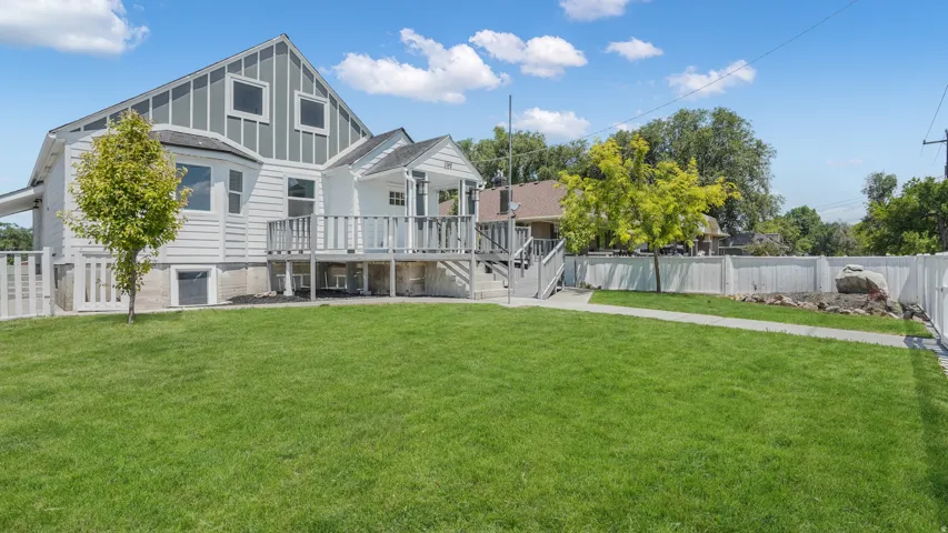 Rear view of house with a fenced backyard, a wooden deck, and board and batten siding