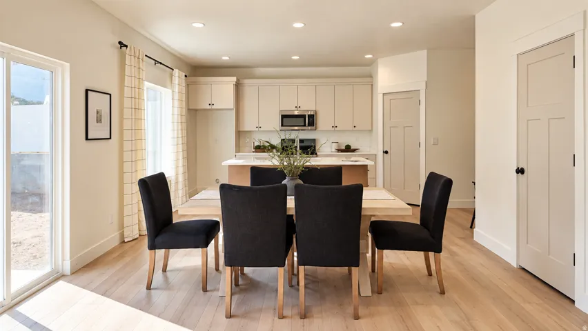 Open concept living space featuring light wood-finish flooring, recessed lighting, and a sliding glass door