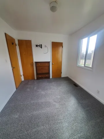 Unfurnished bedroom featuring two closets and carpet flooring