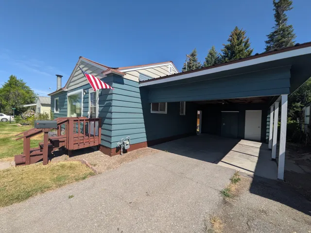 Exterior featuring blue horizontal siding and a covered carport