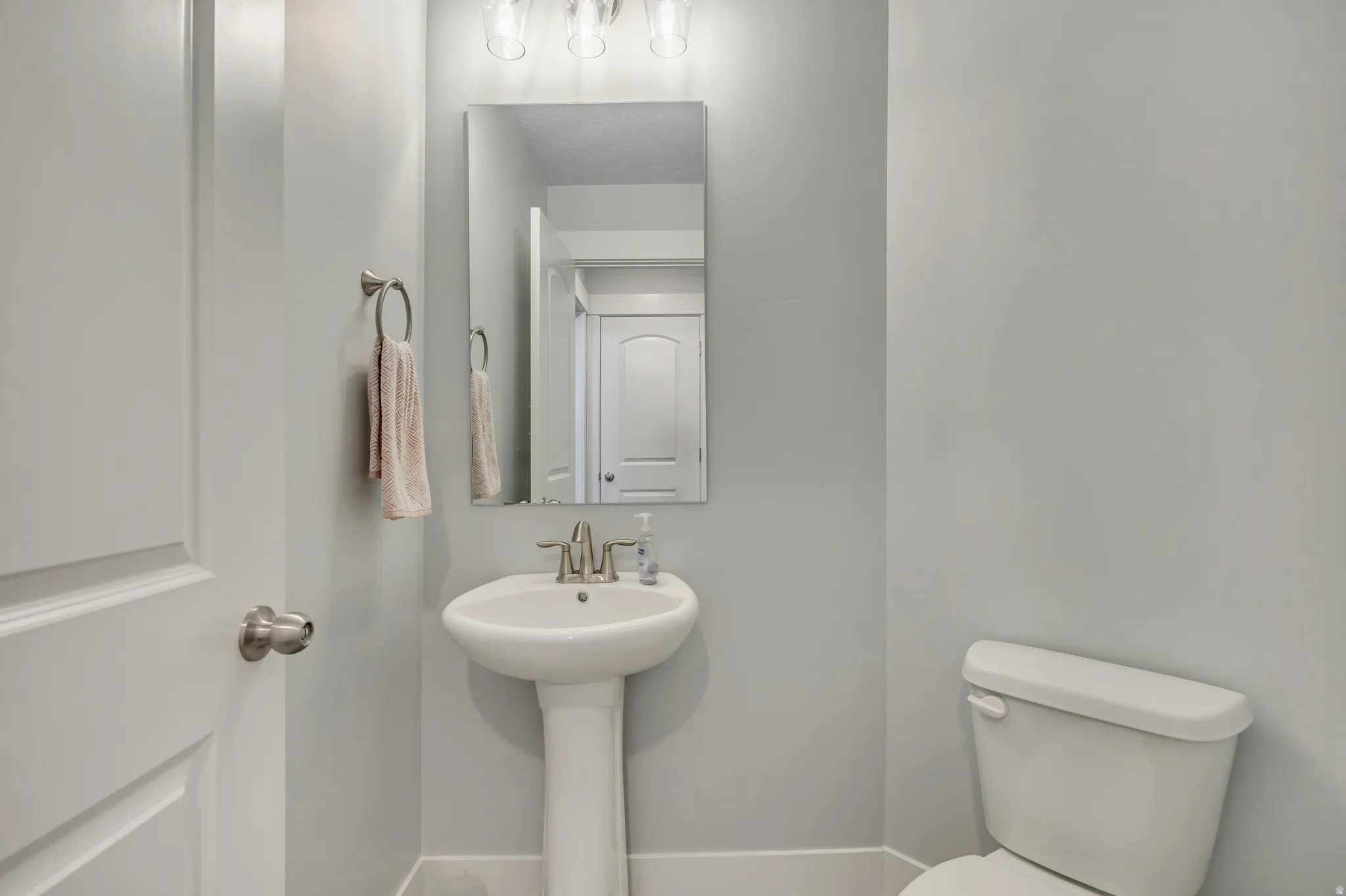 Half bath featuring toilet and baseboards