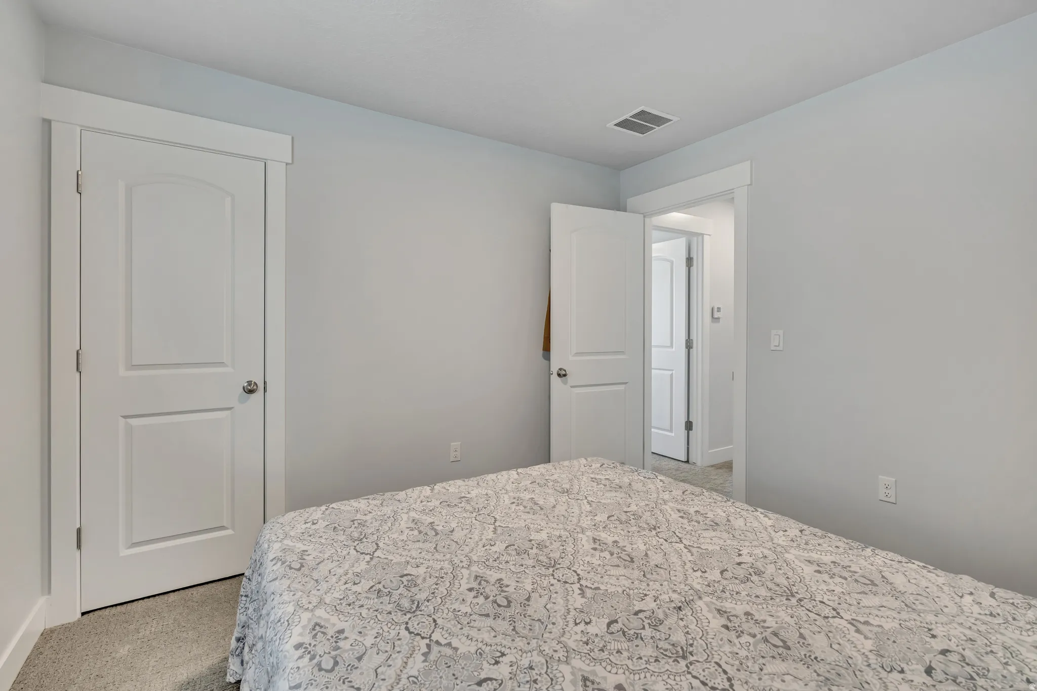 Bedroom featuring light carpet and baseboards
