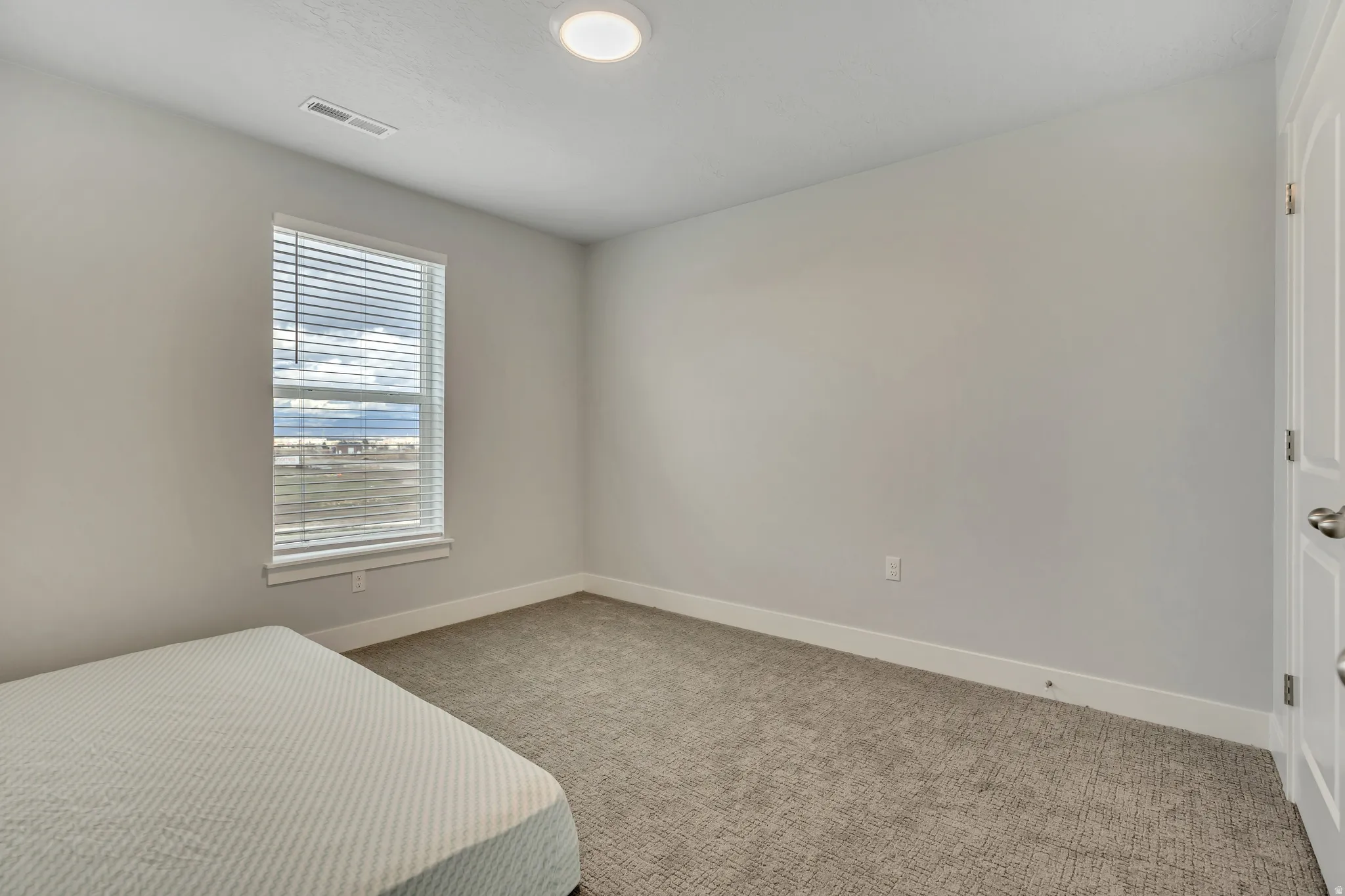 Bedroom featuring light colored carpet and baseboards