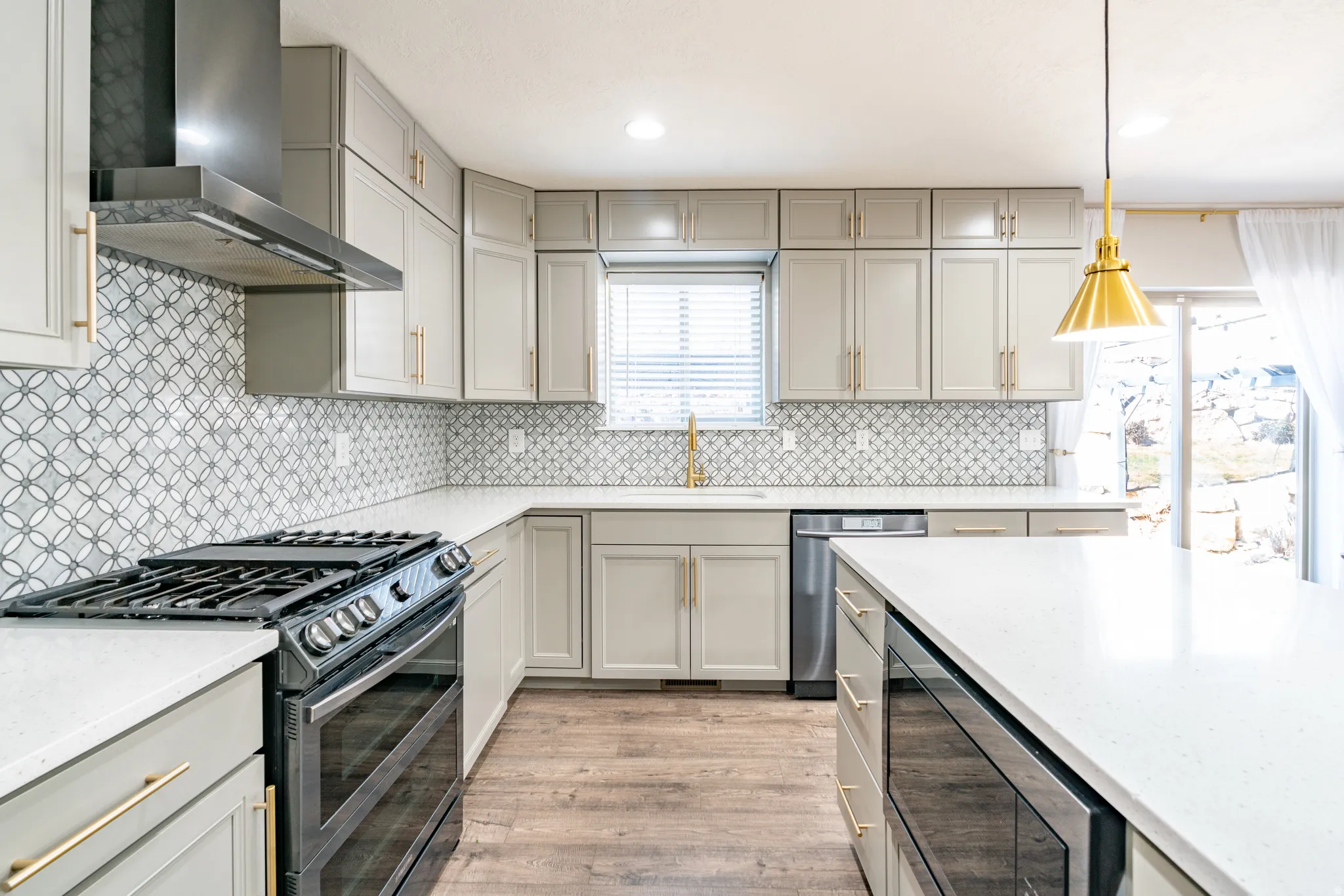 Kitchen featuring stainless steel appliances, gray cabinets, and light stone counters