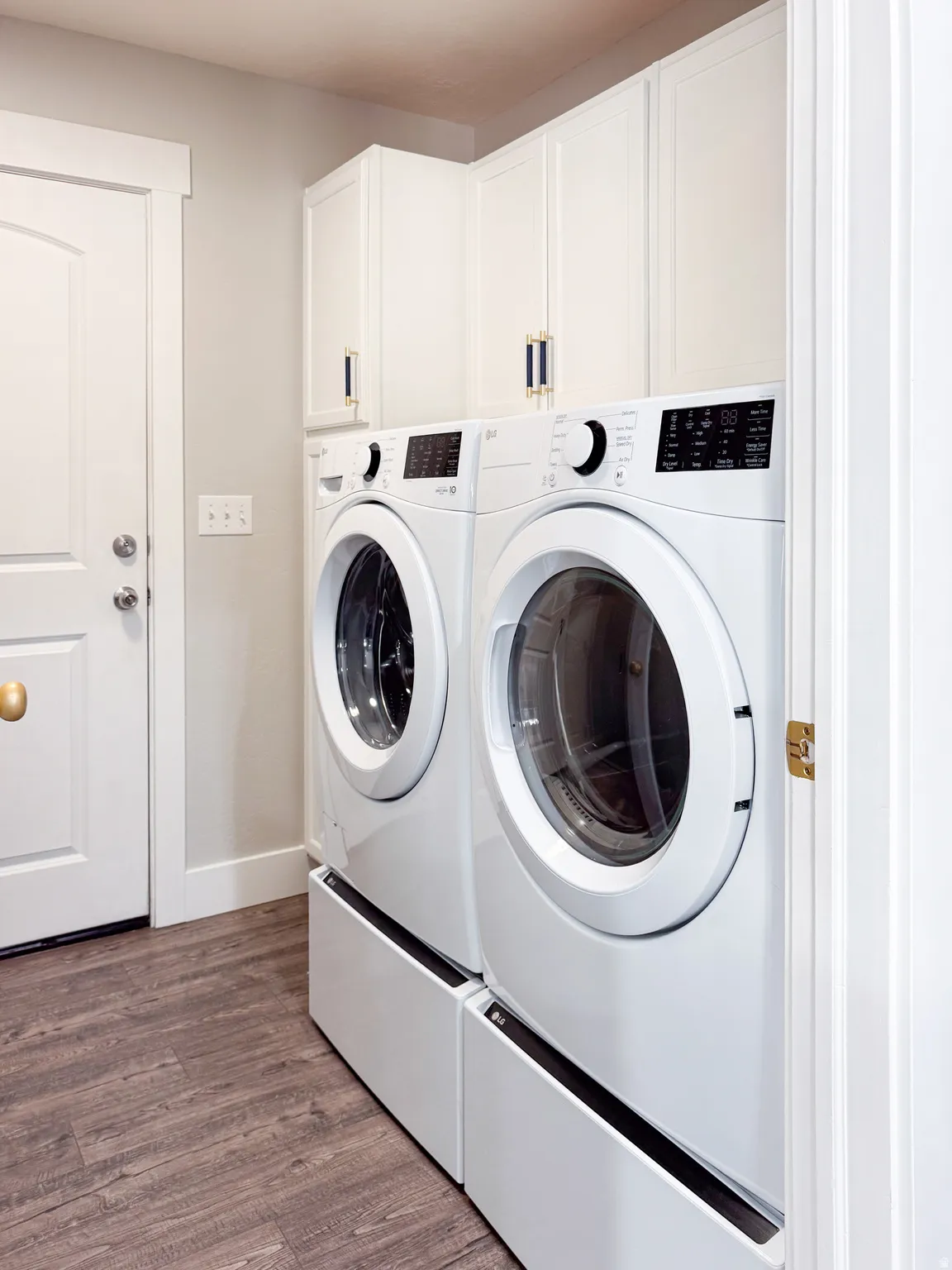 Laundry room with cabinet space, dark wood-style flooring, and washer and dryer
