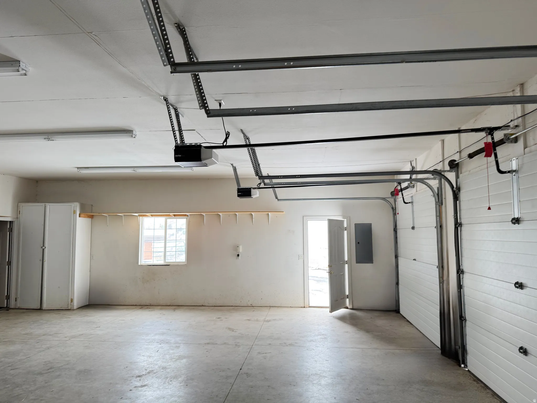 Garage featuring electric panel and a garage door opener